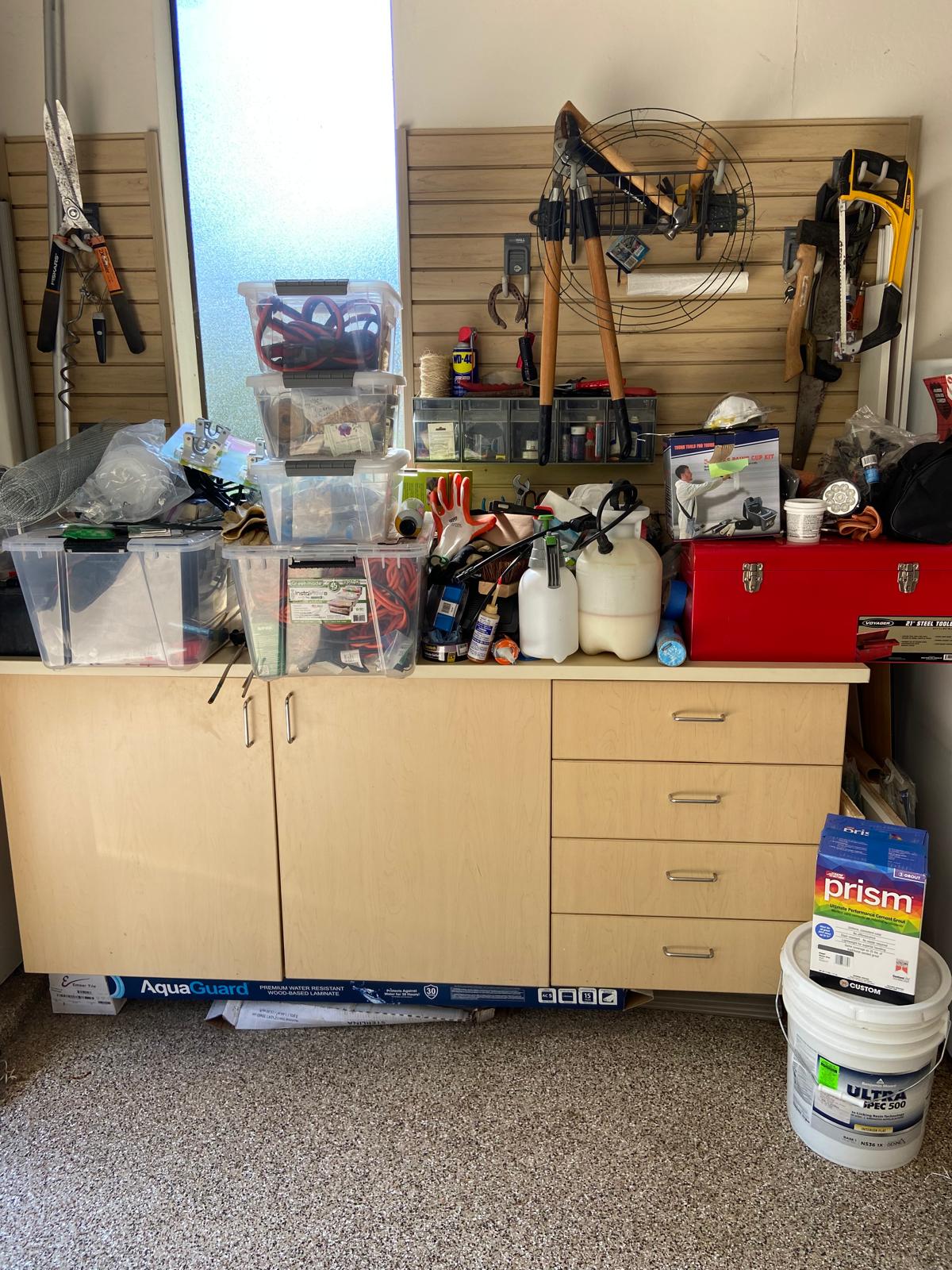 Before organization: tools and supplies crowding the same garage workbench