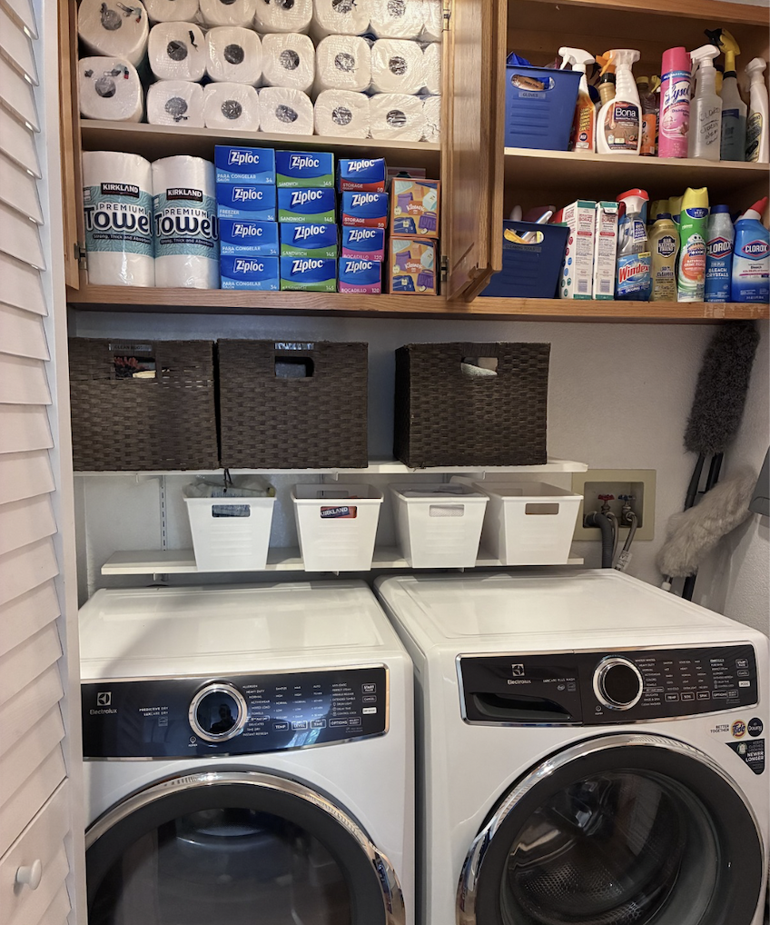 After organization: clear washer and dryer tops, baskets, and supplies grouped in the laundry cabinets